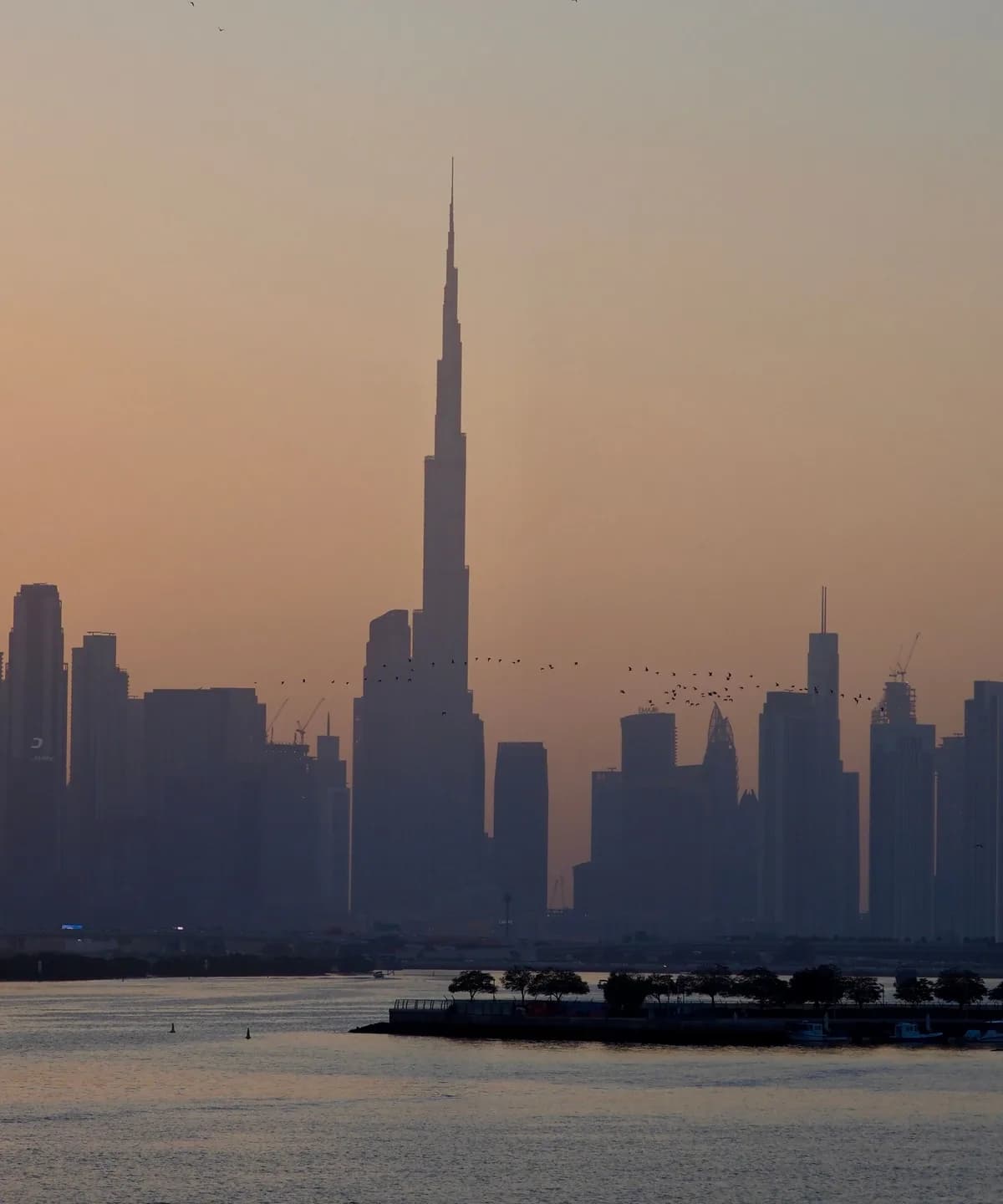 The Dubai skyline at sunset, with the Burj Khalifa rising above Downtown